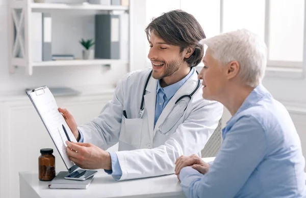 Médico feliz mostrando resultados positivos de la prueba al paciente mayor — Foto de Stock