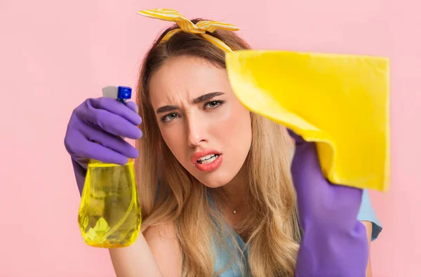 Perfectionism at home cleaning concept. Concentrated housewife wipes stain on camera with spray and sponge — Stock Photo, Image