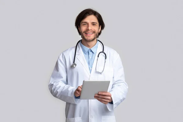 Cheerful doctor using digital tablet in hands — Stock Photo, Image