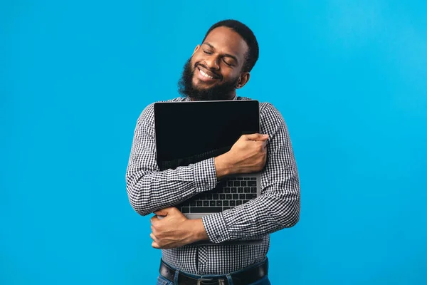 Sonriente afroamericano chico sosteniendo la computadora personal — Foto de Stock