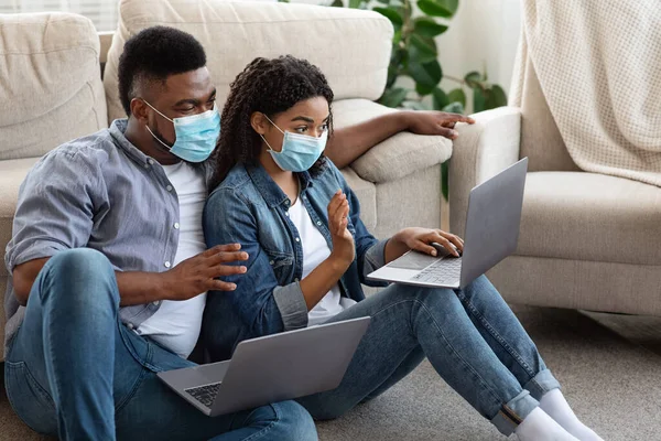 Negro pareja teniendo videollamada con amigos en el ordenador portátil en casa —  Fotos de Stock