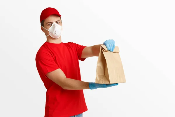 Entrega rápida en casa. Mensajero en máscara médica y guantes sostiene el paquete — Foto de Stock