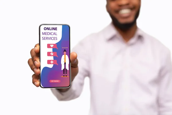 Tipo sosteniendo teléfono con servicios médicos en línea en la pantalla — Foto de Stock