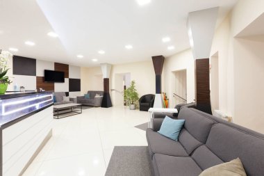 Özel diş hekimliğine giriş, bekleme salonu ve büyük televizyonlu duvar.