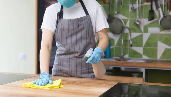 Mujer irreconocible limpiando el mostrador de la cocina en el trabajo —  Fotos de Stock