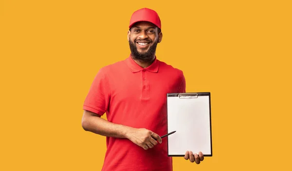 Delivery Man Holding Folder met blanco papier over gele achtergrond — Stockfoto