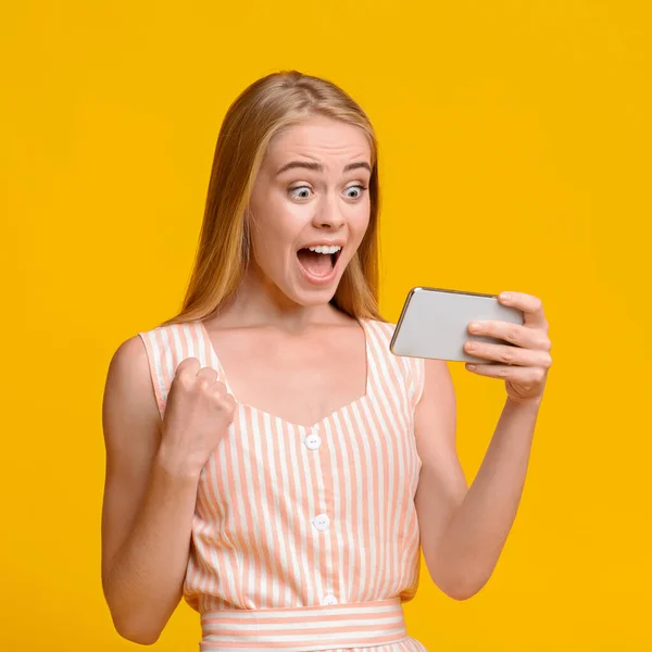 Emotionele tiener meisje verheugen succes met smartphone in handen — Stockfoto