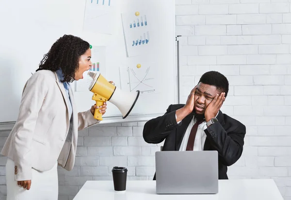 Emocional señora jefe con megáfono gritándole a un empleado masculino en el lugar de trabajo — Foto de Stock