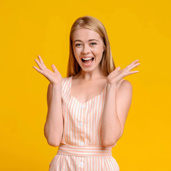 Счастливо удивлен. Радостная девочка-подросток, поднимающая руки с возбуждением, на желтом фоне — стоковое фото