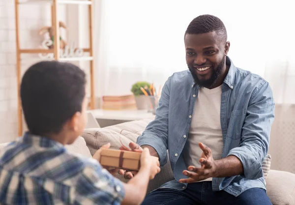 Gelukkig zwart man ontvangen geschenk doos van zijn liefhebbende weinig zoon — Stockfoto