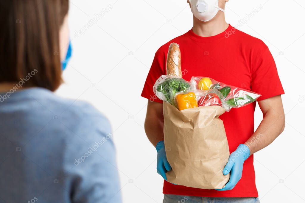 Delivery of products from supermarket during quarantine. Girl receives package of products from courier