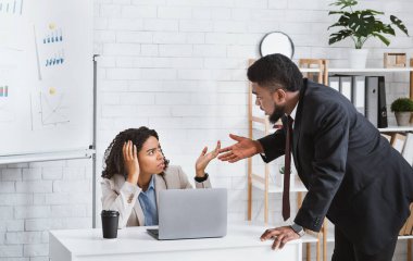 Afrika kökenli Amerikalı iş arkadaşları ofiste birbirleriyle tartışıyor.