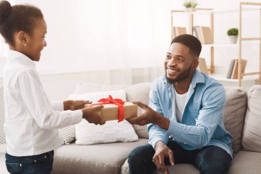 Küçük kız babana sürpriz yapıyor, hediye kutusu veriyor.