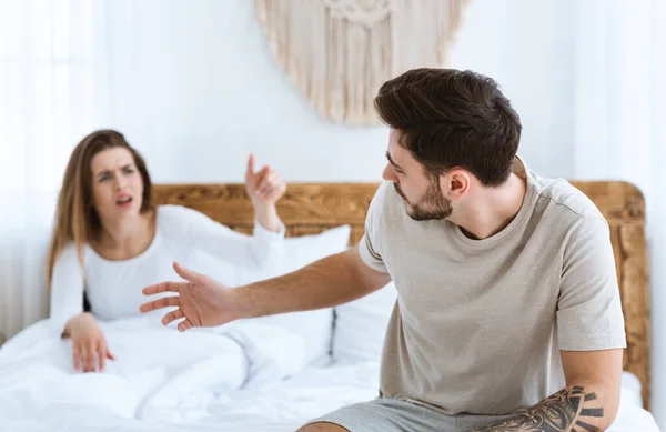 Quarrel na cama. Casal jovem apaixonadamente descobre relacionamento — Fotografia de Stock