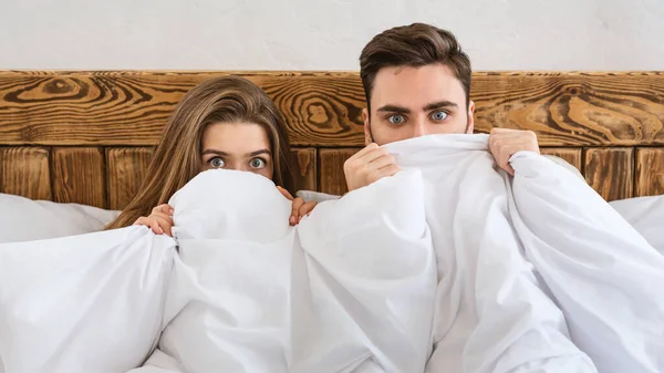 Conceito do medo. Marido e mulher se escondendo no cobertor e assistindo filme — Fotografia de Stock