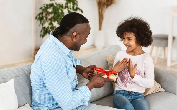 Celebração de aniversário. Afro-americano avô dando caixa de presente para sua neta em casa — Fotografia de Stock