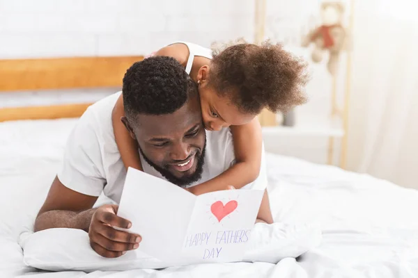Feliz hija africana dando papá tarjeta de felicitación en vacaciones — Foto de Stock