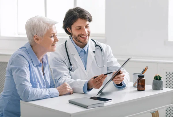 Médico mostrando resultados de análise para paciente sênior — Fotografia de Stock