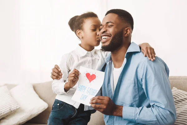Симпатична дочка афро поцілувала тата і давала вітальні листівки — стокове фото