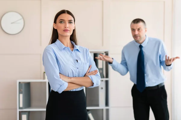 Homme d'affaires criant à la femme employée debout dans le bureau moderne — Photo