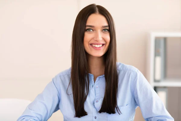 Alegre oficina chica sonriendo a cámara de pie en lugar de trabajo en interior — Foto de Stock