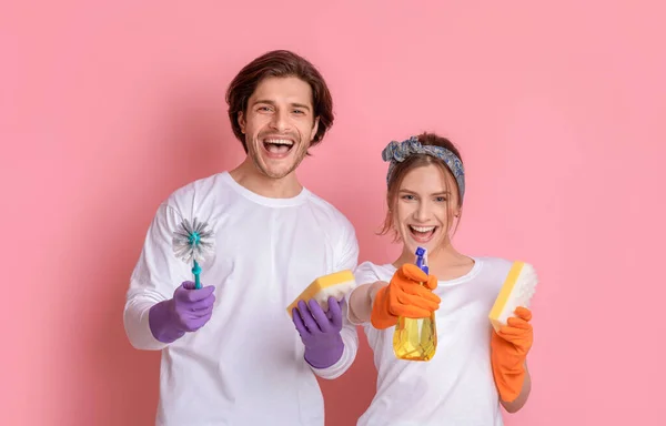 Frühjahrsputz. Fröhliches Millennial-Paar posiert mit Haushaltsgeräten in den Händen — Stockfoto