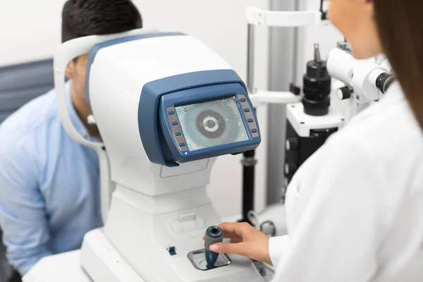 Optometrista che controlla la visione dei pazienti presso la moderna clinica — Foto Stock