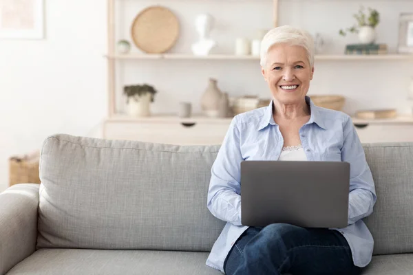 Freiberuflicher Job für Senioren. Ältere Frau arbeitet zu Hause am Laptop — Stockfoto