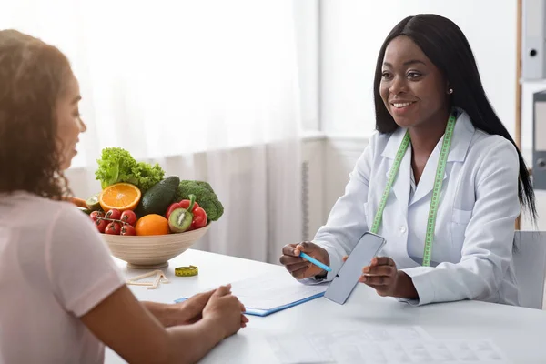 환자에게 칼로리를 계산하는 모바일 앱을 보여 주는 쾌활 한 영양사 — 스톡 사진