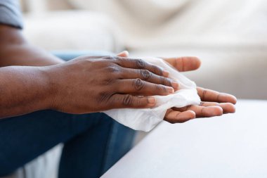 Coronavirus Koruma. Siyah adam evde antibakteriyel mendillerle elleri dezenfekte ediyor