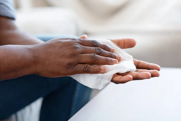 Protección contra Coronavirus. Hombre negro desinfectando las manos con toallitas antibacterianas en casa —  Fotos de Stock