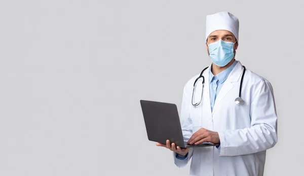 Lekarz w stroju ochronnym pracujący na laptopie, panorama — Zdjęcie stockowe