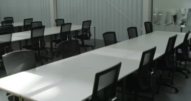 Konferans salonunda uzun boş masalar.