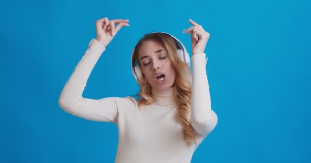 Mujer disfrutando de la música en auriculares inalámbricos y bailando — Vídeo de stock