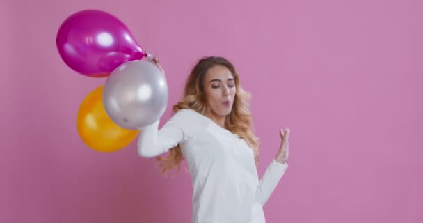 Feliz joven bailando con un montón de globos aerostáticos — Vídeos de Stock