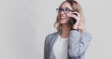 Dost canlısı bayan satış müdürü cep telefonuyla konuşuyor.