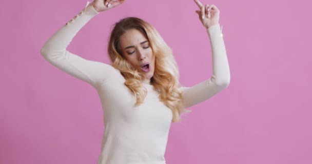 Крутая блондинка танцует, наслаждаясь динамичной музыкой — стоковое видео