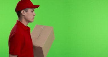 Kurye paketle geliyor ve kameraya gülümsüyor.