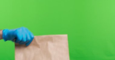 Kurye kadın müşteriye koli veriyor, hem de koruyucu eldivenlerle.