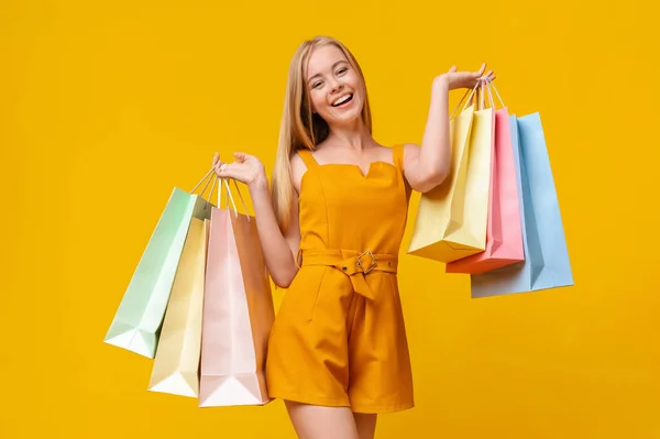 Feliz chica adolescente después de compras exitosas llevando un montón de bolsas de papel —  Fotos de Stock