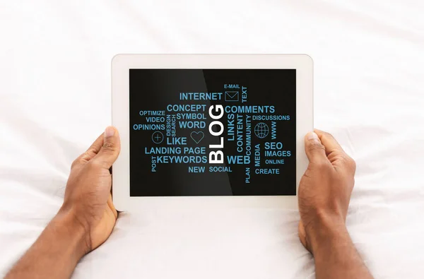 Closeup of African American guy holding tablet computer with blogging related words on screen, collage — Stock Photo, Image