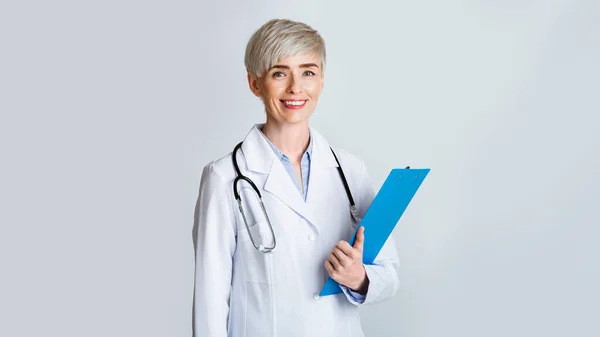 Nowoczesna medycyna. Uśmiechnięta pani doktor z tabletką w dłoni i stetoskopem — Zdjęcie stockowe