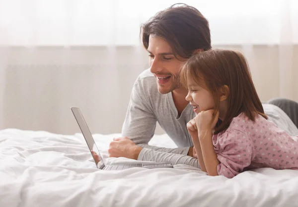 Apa és lánya laptopot használ otthon, mosolyog — Stock Fotó