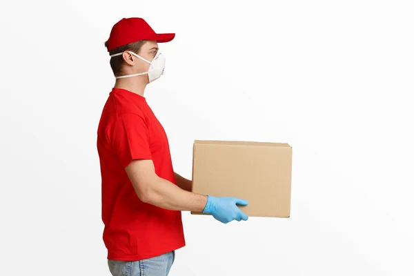 Vydávání balíků během vypuknutí koronaviru. Kurýr v ochranné masce a rukavicích — Stock fotografie