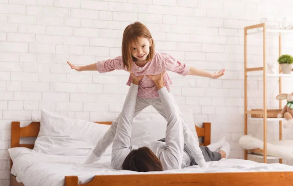 Papá acostado en la cama y sosteniendo a su hijita —  Fotos de Stock