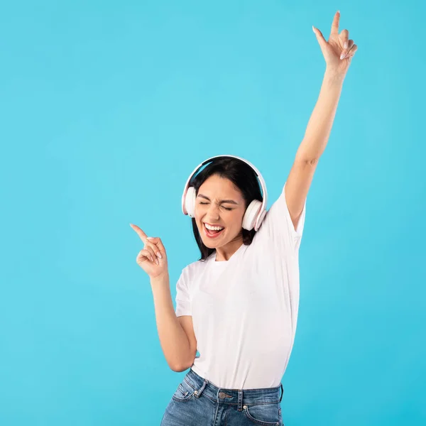 Retrato de menina animada usando fones de ouvido apreciando música — Fotografia de Stock