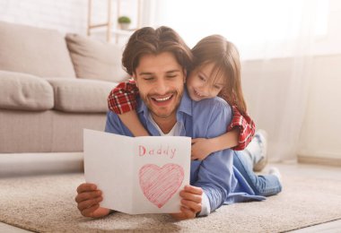 Mutlu baba, kızıyla yakınlaşırken tebrik kartı okuyor.
