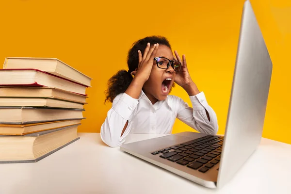 Перероблений школярка sughing в ноутбук сидячи на жовтому фоні студії — стокове фото