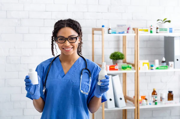 Happy African American veterinary doctor holding different meds in animal clinic, copy space — Stock Photo, Image