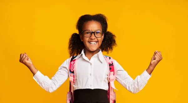 Joyful Elementary School Girl Shaking Fists Over Yellow Background, Panorama — Stok Foto